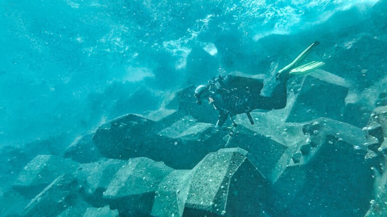 Plongeur CLAS inspectant la carapace d’une digue sous l’eau