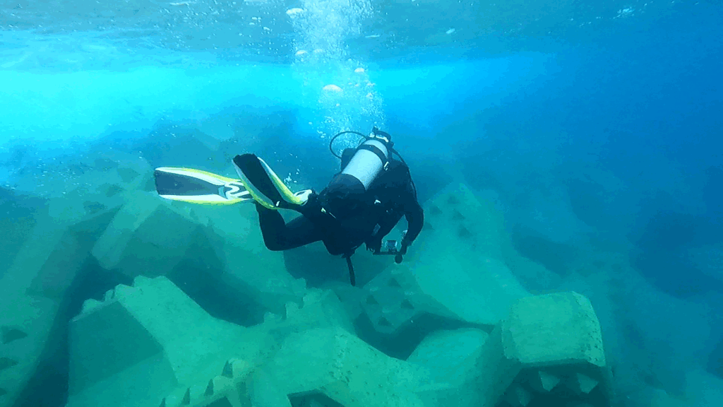 Inspecteur CLAS contrôlant la carapace d’une digue en blocs artificiels en béton.