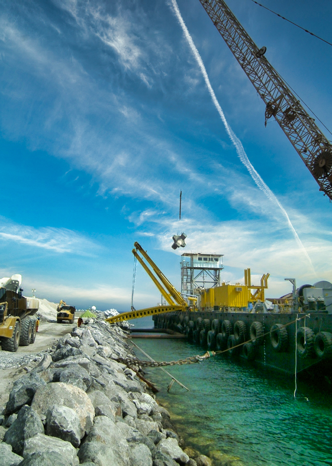 Barge de chantier déchargeant un bloc en béton sur l’île de Zakum lors des travaux de construction supervisés par CLAS.