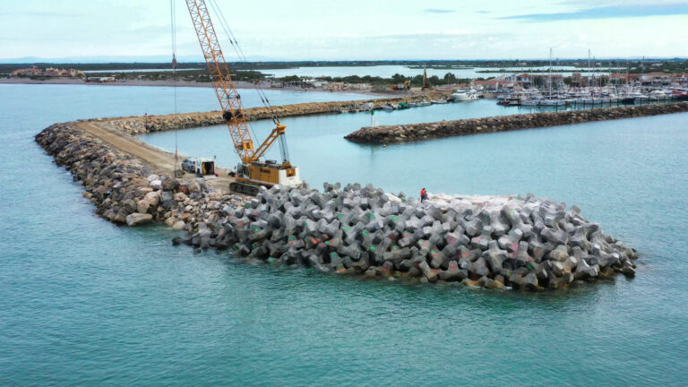 Vue drone montrant l’équipe CLAS construisant le musoir de la digue avec des blocs artificiels.