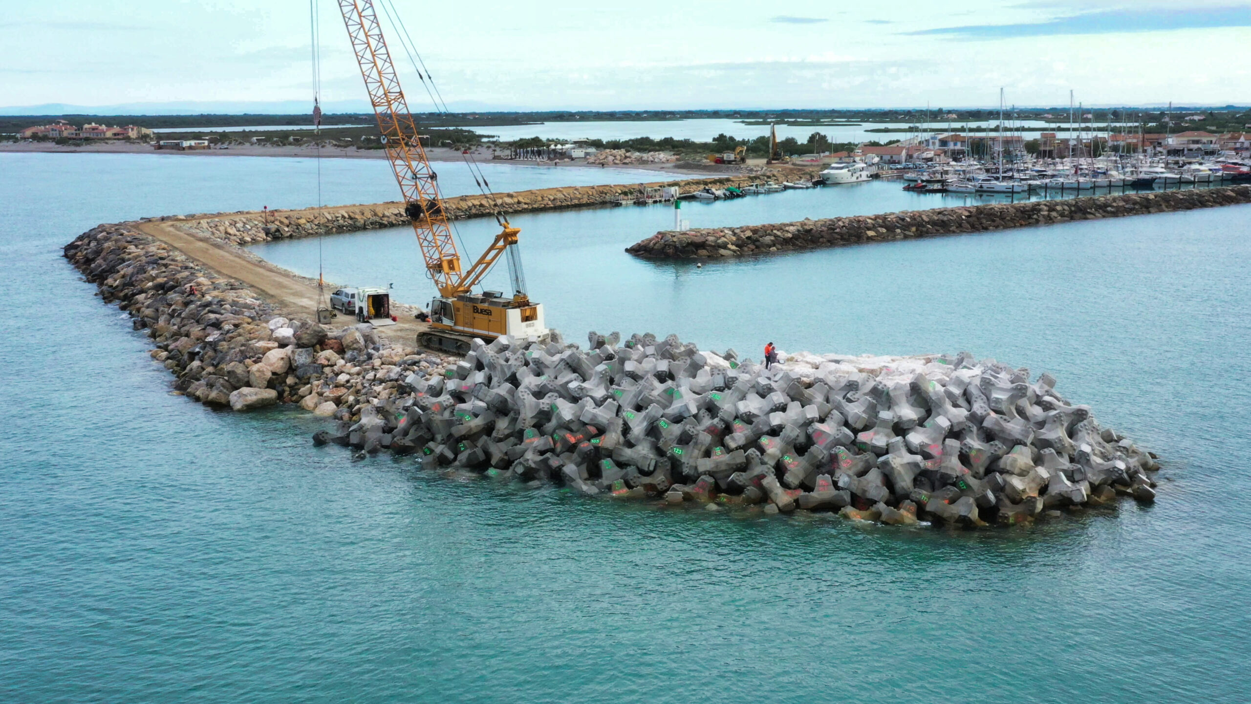 Vue drone montrant l’équipe CLAS construisant le musoir de la digue avec des blocs artificiels.