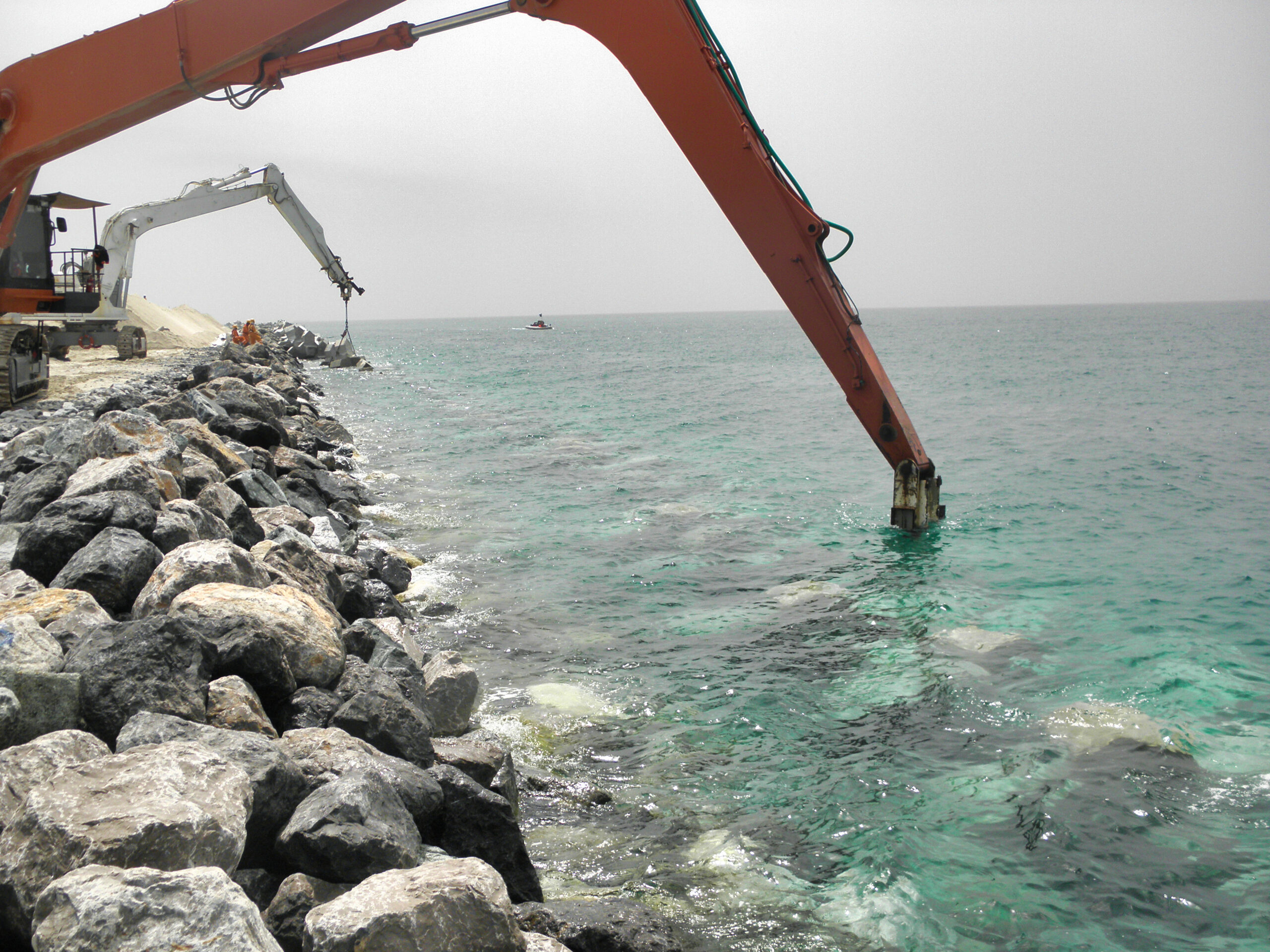 Pose des blocs de carapace sur la digue de Das Island sous supervision CLAS pour garantir une imbrication correcte et durable.