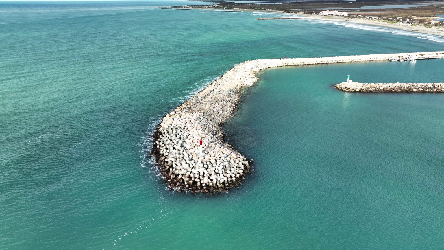 Vue drone montrant la carapace finie en blocs artificiels, parfaitement imbriqués sur la digue.
