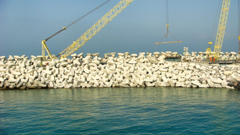 Pose des blocs artificiels sur le chantier de Ras Laffan sous la supervision de CFE, montrant l’organisation du travail et l’imbrication des unités.
