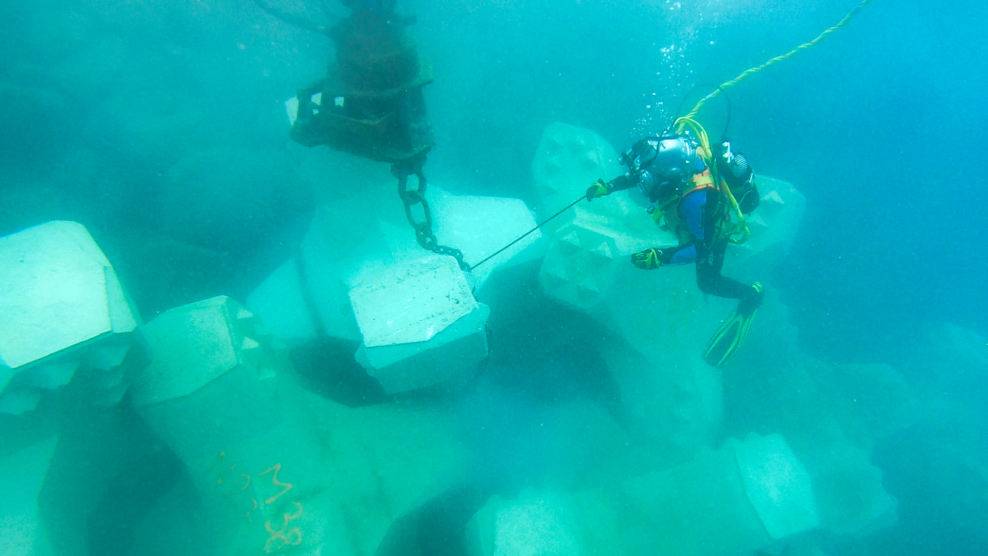 Plongeur professionnel CLAS positionnant un bloc artificiel sous l’eau sur la digue de Port-La-Nouvelle.
