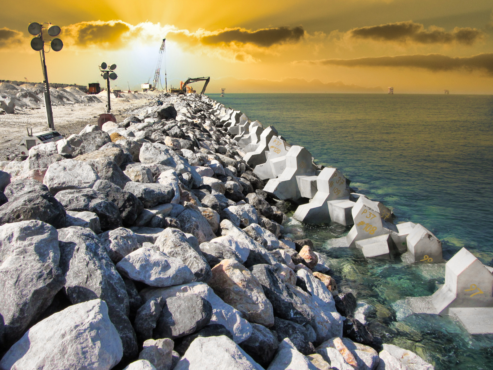Avancement de la carapace en blocs artificiels sur Upper Zakum Middle Island, montrant la progression du chantier.