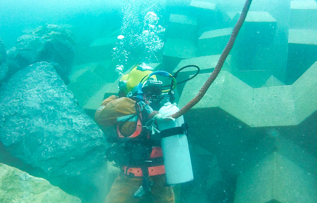 Plongeur CLAS inspectant sous l’eau la carapace en blocs artificiels sur Upper Zakum South Island.