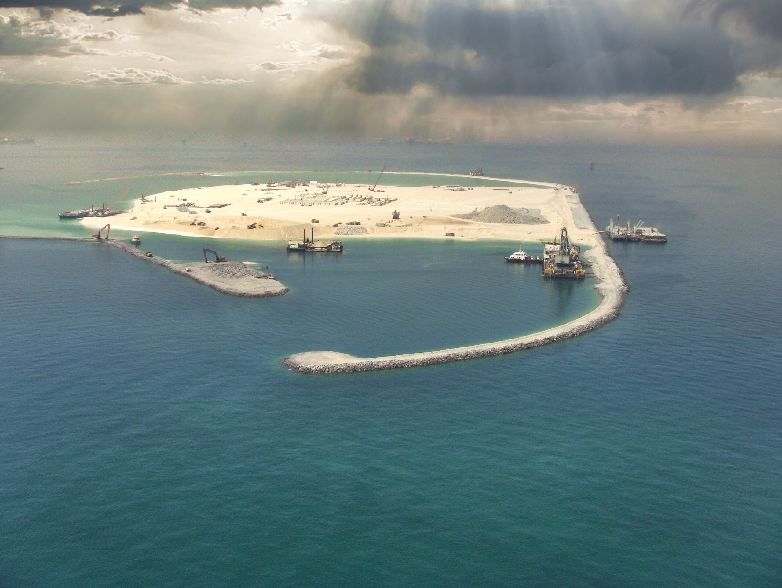 Vue aérienne d’Upper Zakum West Island montrant les travaux de construction de la digue et de la carapace en blocs artificiels.