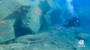 Plongeur CLAS inspectant le pied de la carapace en blocs ACCROPODE™ II posé dans une tranchée à Bastia
