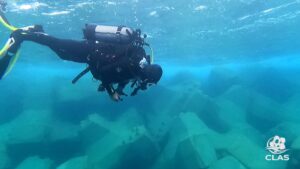 Plongeur CLAS inspectant près de la surface la carapace ACCROPODE™II à Bastia pour sa certification